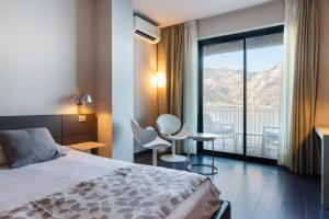 a hotel room with a bed and a large window at Piccolo Hotel in Malcesine +84 photos