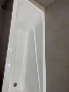 a shower with a white bath tub in a bathroom at Designer Apartment with Mountain View in Almaty