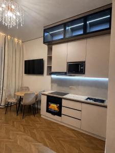 a kitchen with a stove and a table with chairs at Designer Apartment with Mountain View in Almaty