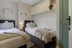 two beds in a room with white walls at Riverside Crossing in Worcester