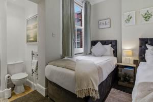 a bedroom with a bed and a toilet and a window at Riverside Crossing in Worcester +3 photos