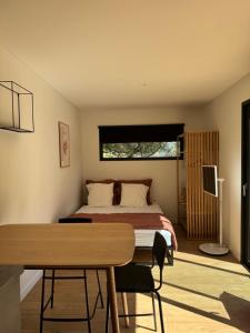 a bedroom with a bed and a table and a desk at Lodges sous les oliviers in Propriano
