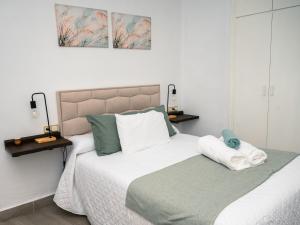 a bedroom with a bed with white sheets and green pillows at Casa isabel in Setenil