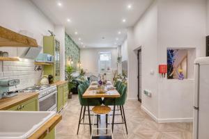 a kitchen with green chairs and a table in it at Eclectic Maisonette in Luqa in Luqa
