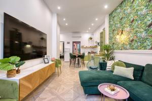 a living room with a green couch and a table at Eclectic Maisonette in Luqa in Luqa