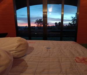 a bed in a room with a view of a sunset at Cozzy Bitu Garden in Bunder +21 photos