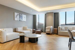 a living room with white furniture and a table at Four Points by Sheraton Elazig in Elazığ