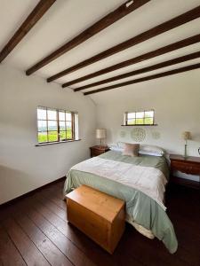 a bedroom with a large bed and two windows at Bay View Ridge Cottage in Bantry