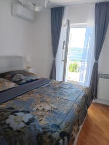 a bedroom with a bed and a large window at Hanna in Dramalj