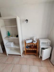a room with a kitchen with a refrigerator and a microwave at Etage privatif au calme - 2 chambres & salle de bains in Barret-de-Lioure