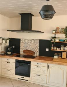 a kitchen with a counter with a stove top oven at Propriété avec piscine in Vensac