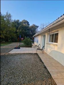 a bench sitting on a sidewalk next to a house at Propriété avec piscine in Vensac