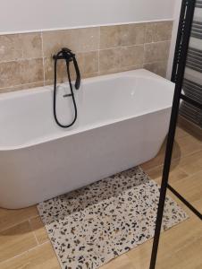 a white bath tub sitting on top of a rug at Propriété avec piscine in Vensac +8 photos