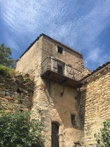 a building with a balcony on the side of it at Tour médiévale in Saint-Georges-de-Luzençon