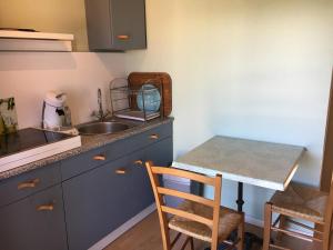 a kitchen with a sink and a counter with a table at Tour médiévale in Saint-Georges-de-Luzençon