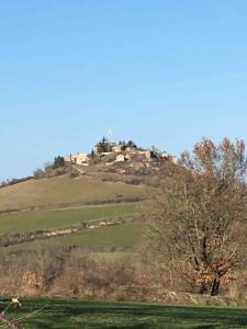 a hill with a house on top of it at Tour médiévale in Saint-Georges-de-Luzençon