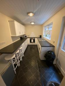 a kitchen with white cabinets and a black counter top at spamount house in Belfast