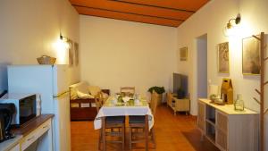 a kitchen with a table and a refrigerator in a room at Vila Dias in Mértola