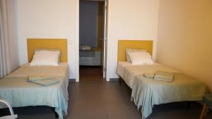 a room with two beds with towels on them at Vila Dias in Mértola