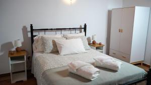 a bedroom with a bed with two towels on it at Vila Dias in Mértola