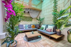 a living room with blue couches and plants at Eclectic Maisonette in Luqa in Luqa