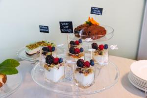 a table topped with three cakes and desserts on plates at Piccolo Hotel in Malcesine