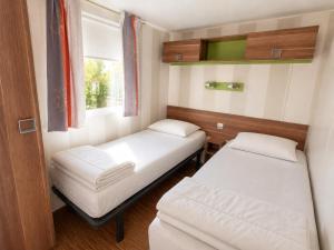 a small room with two beds and a window at Camping de la Baie-Baie de Somme-Sites et Paysages in Pendé