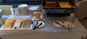 a table with a tray of bread and plates of food at Esatitude Hotel in Nice