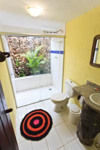 a bathroom with a toilet and a sink and a window at Pousada Veredas, Café e 08 cachoeiras na propriedade incluso ! in Cavalcante