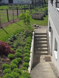 a garden with stairs and plants next to a building at Utting Schulstrasse in Utting am Ammersee