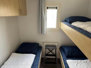 ein kleines Zimmer mit zwei Etagenbetten und einem Fenster in der Unterkunft J 187 in Petten