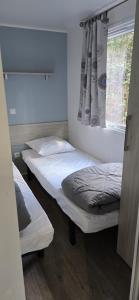 two beds in a room with a window at Camping Fontisson in Châteauneuf-de-Gadagne +56 photos
