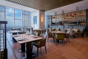 a restaurant with tables and chairs and large windows at Huzhou Marriott Hotel Nanxun in Huzhou