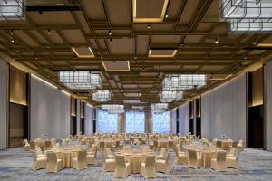 a large banquet hall with tables and white chairs at Huzhou Marriott Hotel Nanxun in Huzhou +47 photos