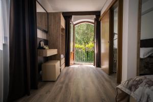 a bedroom with a hallway with a bed and a window at Albergo Pineta dal 1891 in Villetta Barrea