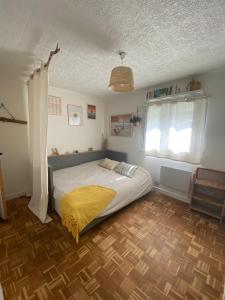 a bedroom with a bed with a yellow blanket on it at Maison familiale Tarnos, 4 chambres, jacuzzi in Tarnos