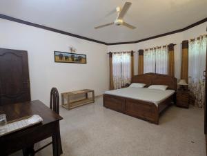 a bedroom with a bed and a desk and a piano at Arangala View in Elhanyaya