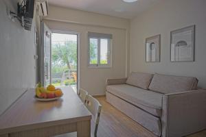 a living room with a couch and a table with a bowl of fruit at Dimitra Apartments in Kanali +48 photos
