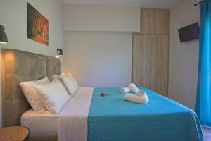 a bedroom with a bed with two stuffed animals on it at Dimitra Apartments in Kanali