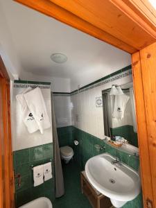 ein grünes Badezimmer mit Waschbecken und Toilette in der Unterkunft Hotel Tesoriero in Panarea