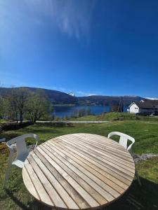 a wooden table and chairs with a view of a lake at Kårhus på småbruk in Lia +9 photos