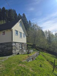 a stone house with a stone wall in a field at Kårhus på småbruk in Lia