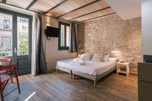 a bedroom with a bed and a brick wall at Aromatik apartments in Girona