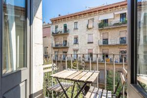 a table and chairs on a balcony with a building at Aromatik apartments in Girona