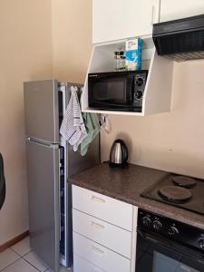 eine kleine Küche mit Kühlschrank und Mikrowelle in der Unterkunft Coco 's Hamlet Flatlet in Prince Alfreds Hamlet + 5 Fotos