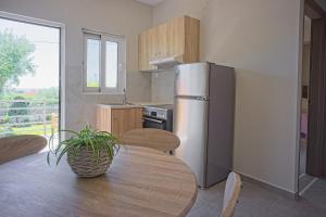 a kitchen with a table and a refrigerator at Dimitra Apartments in Kanali