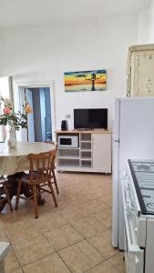 a kitchen with a table and a dining room at A-mare Casa vacanza in Gagliano del Capo