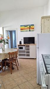 a living room with a table and a refrigerator at A-mare Casa vacanza in Gagliano del Capo