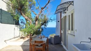 a room with a table and a view of the ocean at A-mare Casa vacanza in Gagliano del Capo +42 photos