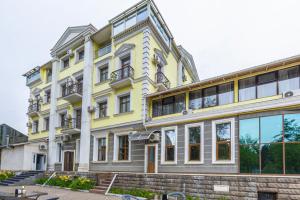 a yellow and white building with windows at AYKUN Hotel in Almaty